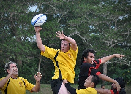 A man catching a rugby ball during a game.