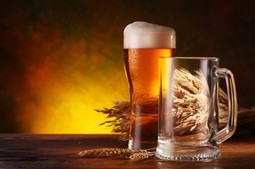 A pint of beer on a wooden table.