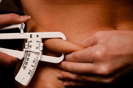 A person pinching their abdominal fat.