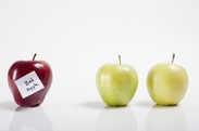 A red apple with the label "bad apple" next to two green apples.
