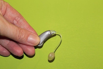 A hearing aid on a green background.