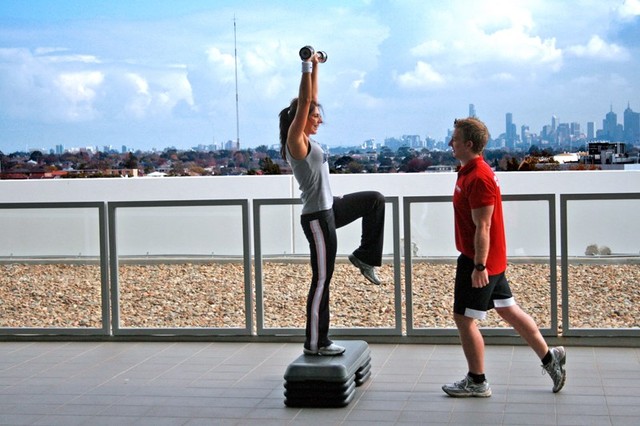 A personal trainer with a client training outside.