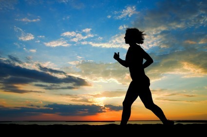 A woman running in the sunset.