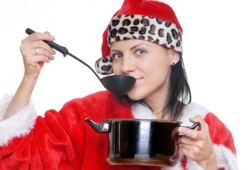 A woman cooking and tasting soup in a Christmas outfit.