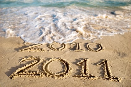 A beach with 2010 and 2011 written on the sand.
