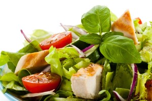 A close up shot of a tomato and chicken salad.