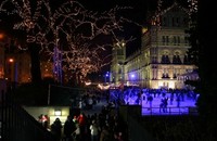 A group of people ice skating at night.