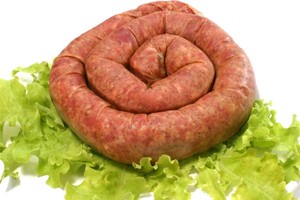 A home made sausage on a bed of lettuce.