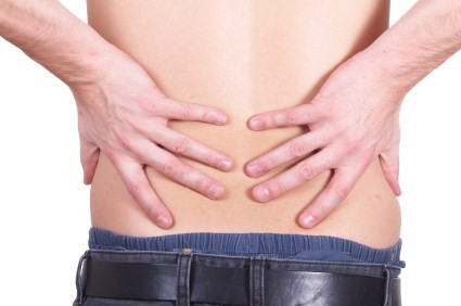A person with back pain holding their back.