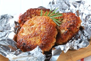 Three vegetable burgers on a sheet of tin foil.