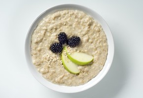 A bowl of porridge with apple and blackcurrant.