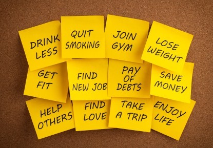 A selection of New Year goals written on yellow post it notes.