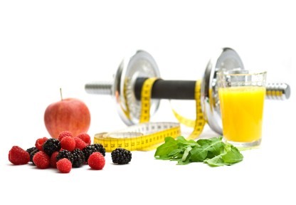 A dumbbell wrapped in a tape measure and surrounded by fruit.