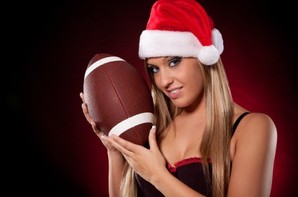 A woman in a Christmas hat holding a rugby ball.