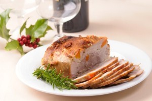 A joint of roast pork on a Christmas table.