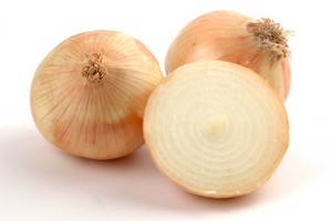Two full onions and one onion chopped in half on a white background.