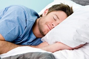 A man smiling and sleeping.