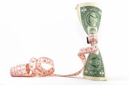 A tape measure wrapped around a paper money note.