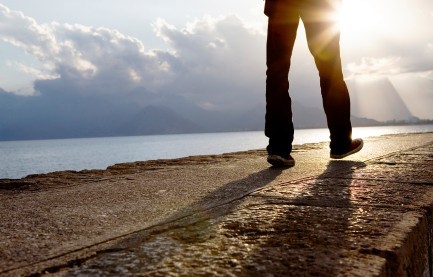 A person's legs walking down a stone path.