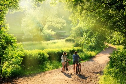 A couple cycling in the park during summer.