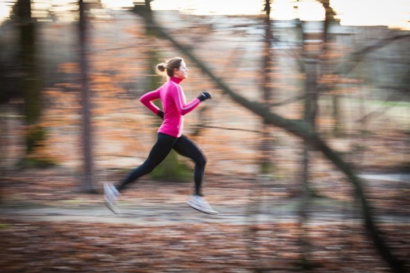 A woman running outside in the woods.