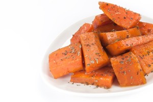 A pile of cooked sweet potato chunks on a white plate.