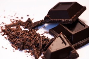 Chunks and ground pieces of dark chocolate.