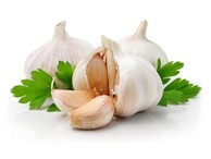 Three cloves of garlic with some parsley.