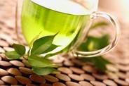 A clear, glass cup of green tea.