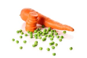 A large carrot and a selection of green peas on a white background.