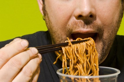 A man eating lots of noodles.