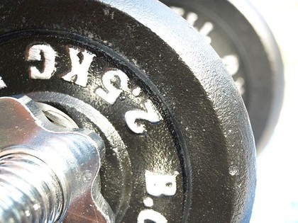 A close up shot of a dark grey dumbbell.