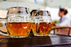 Two half pints of beer on an outdoor table.