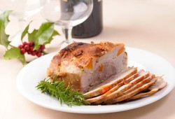 A joint of roast pork on a Christmas table.