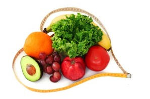 A selection of fruits and vegetables wrapped in a heart shaped tape measure.