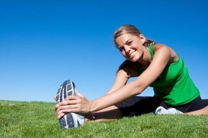 A woman stretching in a field.