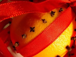 An orange with Christmas decorations.