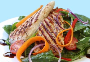 Chicken breasts on top of a vegetable selection.