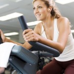 A woman training on an exercise bike.