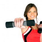 A woman smiling and exercising with dumbbells.