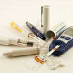 A set of diabetes instruments including a glucometer and an insulin syringe.