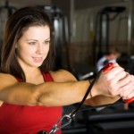 A woman exercising with a resistance cable.