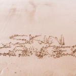 The words 'Skin Cancer' written in sand.