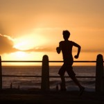 A woman running towards a sunset.