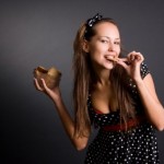 A woman eating a handful of cookies.