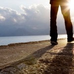 A person's legs walking down a stone path.