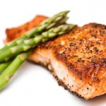 A portion of grilled salmon topped with asparagus.