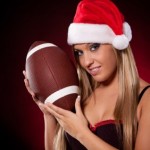 A woman with a Christmas hat holding a football.