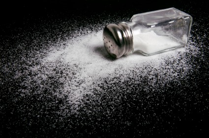 A spilled salt shaker on a black background. A spilled salt shaker on a black background.
