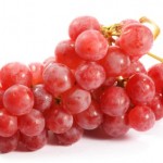 A bunch of red grapes on a white background.